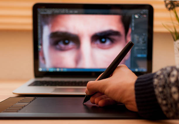 Digital retoucher retouching a photo with pen tablet