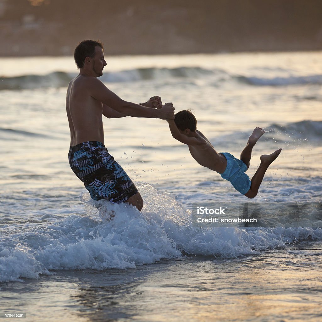 Vater und Sohn spielen am Strand bei Sonnenuntergang - Lizenzfrei Aktivitäten und Sport Stock-Foto