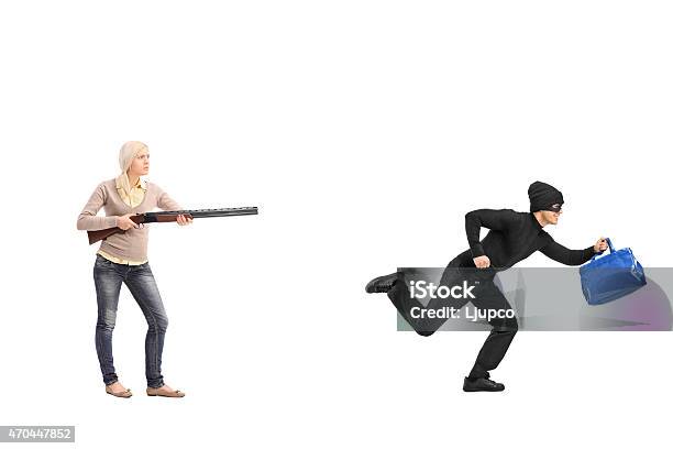 Angry Woman Chasing A Burglar With A Shotgun Stock Photo - Download Image Now - 20-29 Years, 2015, Adult