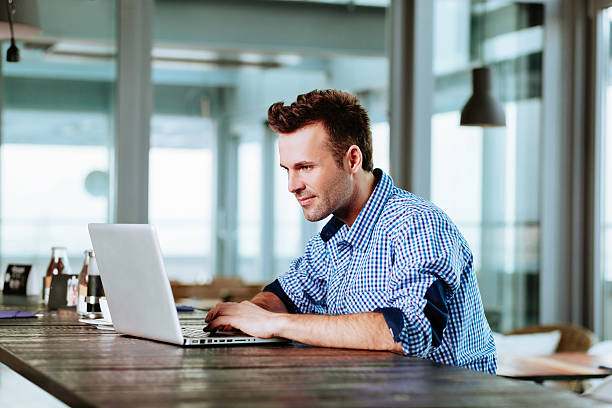 istock Young man at cafe typing on laptop 470448674