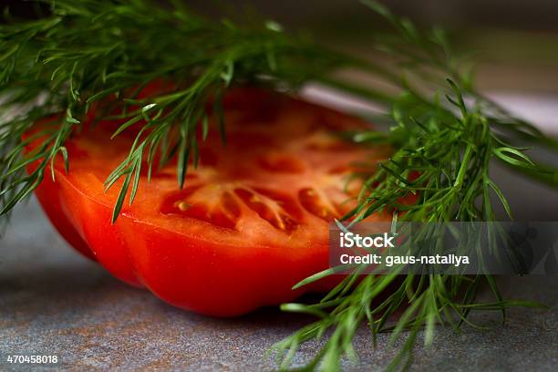 Tomato Cut With A Knife On A Gray Background And Dill Stock Photo - Download Image Now