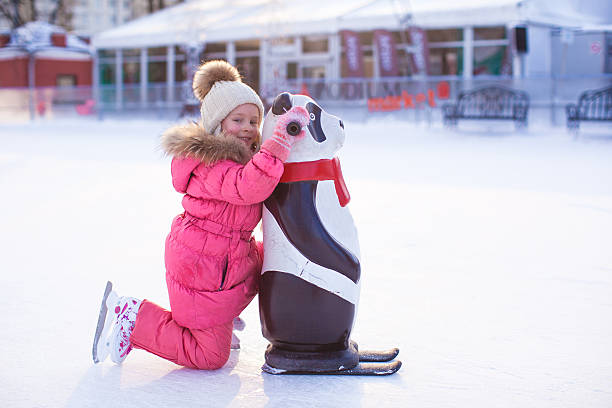 piccolo ragazza felice pattinaggio sul ghiaccio-rink - ice skating sports venue animal winter foto e immagini stock