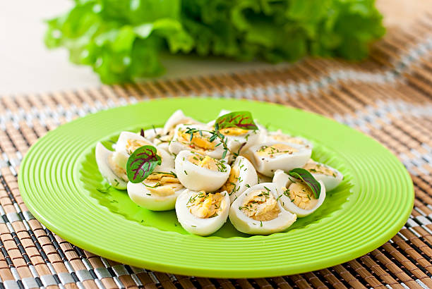 istock Boiled quail eggs halves on a green plate 470470526