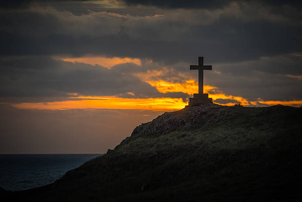 Cross at sunset on Ynys Llanddwyn, Anglesey, Wales stock photo