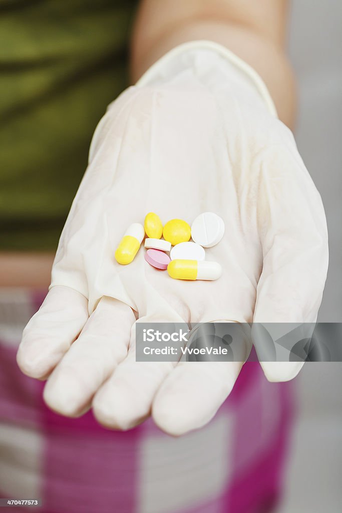 several pills in gloved hand several pills in gloved hand close up Adult Stock Photo