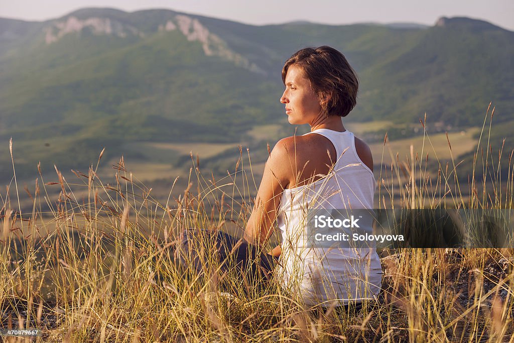 Calm smiling woman enjoyed with gently shining sun Calm smiling woman facing the rising sun into the mountain locality Only Women Stock Photo