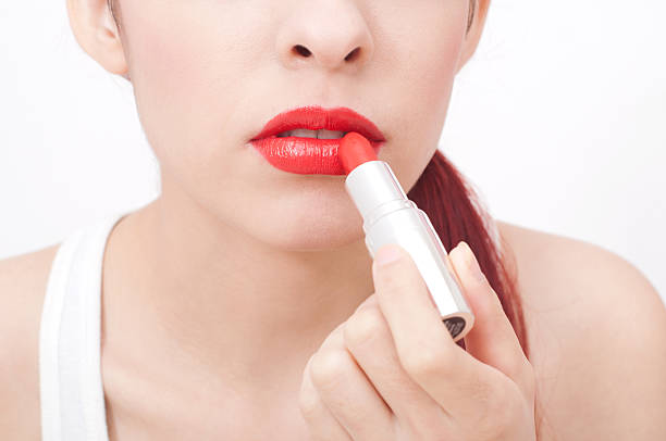 istock Beautiful woman applying lipstick 470480741
