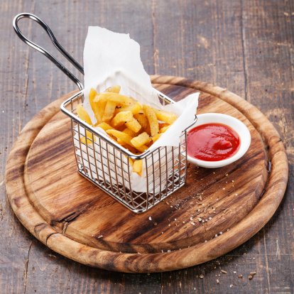 French fries in baskets for serving on wooden background