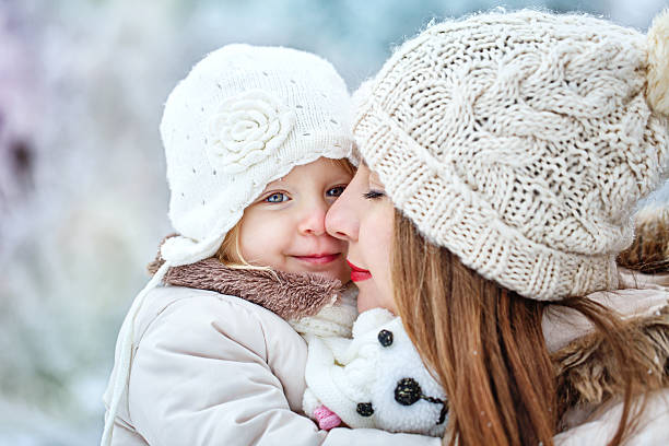 istock Mother holds daughter on hands in winter forest 470489169