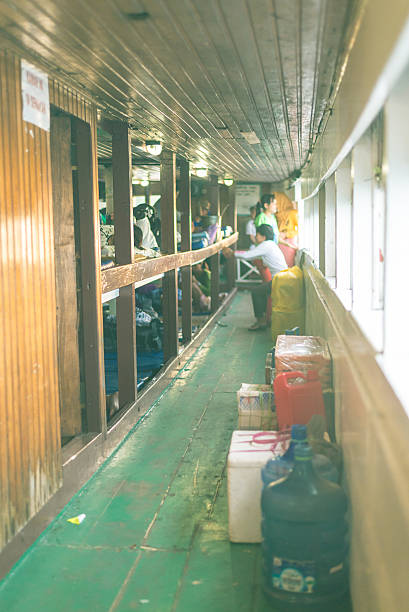 Ampana, Sulawesi, Indonesia - August 28, 2014: People sitting or lying on the benches of an old crowded ship heading from Ampana to the Togean (or Togian) Islands, Central Sulawesi, Indonesia.