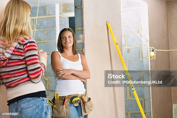 Frau Mit Toolbelt Gespräch Mit Freund Stockfoto und mehr Bilder von Arbeiten - Arbeiten, Arme verschränkt, Ausrüstung und Geräte