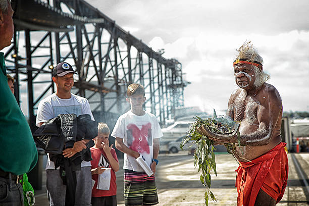 Australian aborigine performs a smoking ceremony Sydney,Australia - April 12,2015: Aboriginal elder Uncle Max Eulo performs a smoking ceremony at an urban regeneration event in White Bay. He has also performed for the pope and Oprah Winfrey. indegious culture stock pictures, royalty-free photos & images