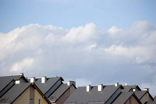 Row house roofs, condo rooftop panorama and bright summer cloudscape