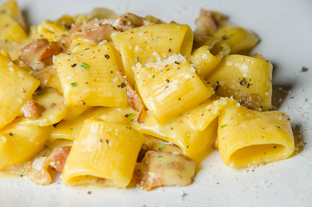 auténtica cocina italiana tradicional carbonara pasta con tocino y huevos - rigatoni fotografías e imágenes de stock