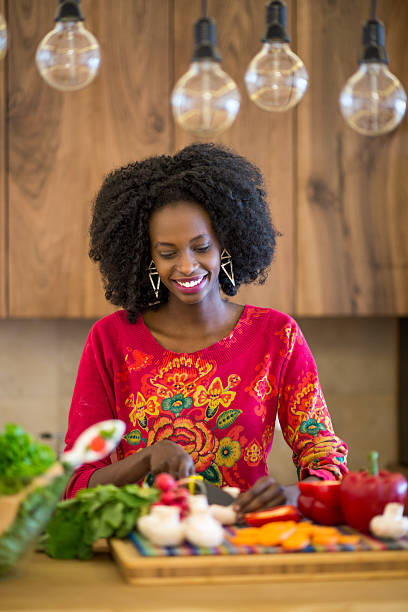 istock Black woman cutting vegetables 470509086