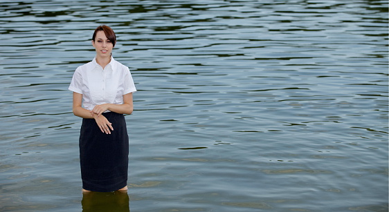 Portrait of businesswoman standing in lake