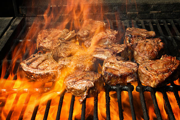 istock Six Thick Juicy Pork Chops on Grill With Leaping Flames 470509432