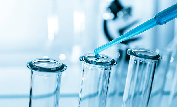 Pipette adding fluid to one of several test tubes .medical stock photo