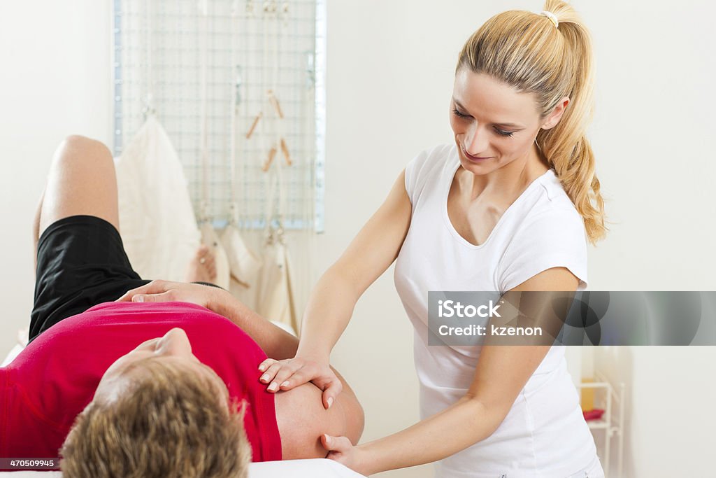 Paziente a fisioterapia facendo terapia fisica - Foto stock royalty-free di Accudire