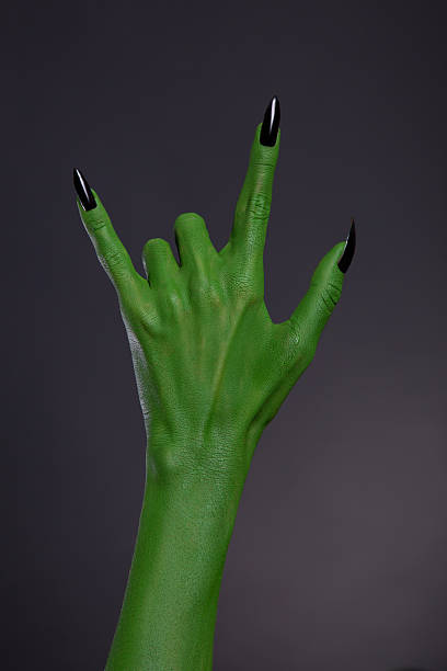 グリーンモンスター手にブラックの爪を示すヘビーメタルのジェスチャー - zombie aggression monster indoors ストックフォトと画像
