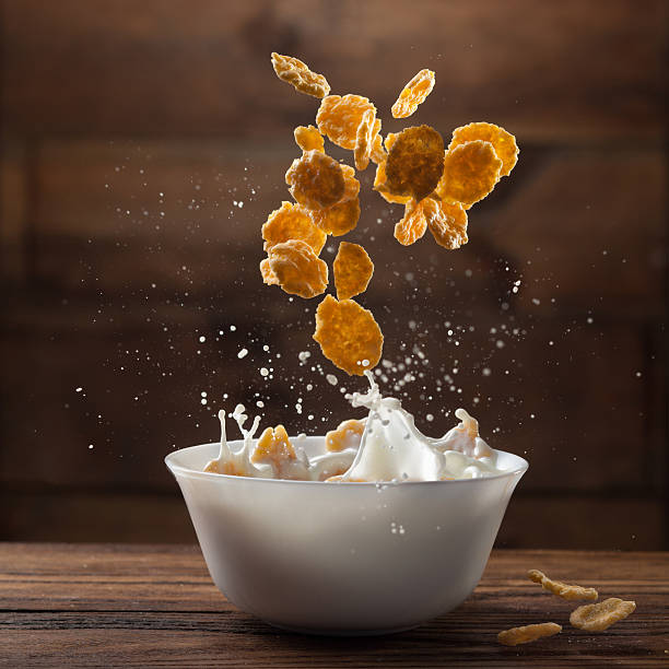 istock Falling corn flakes with milk splash on wood 470517448