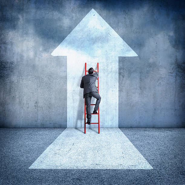 Businessman climbing ladder towards success
