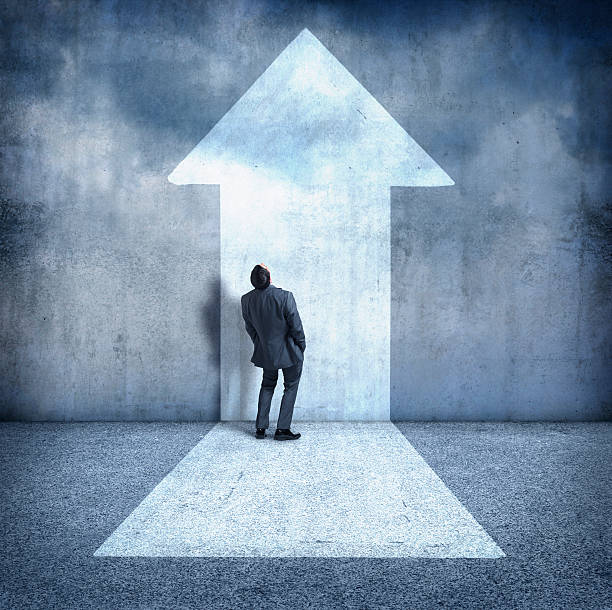 istock Businessman bending over backwards looking up at arrow 470519462