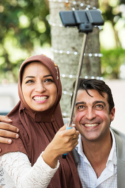 sorrindo do oriente médio, tirando uma foto de casal de estacionamento - cairo women middle east islam - fotografias e filmes do acervo