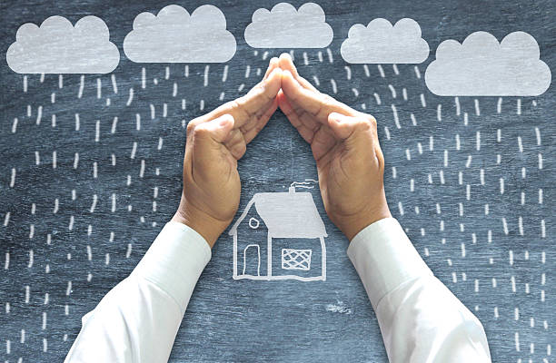 Hands Protecting House Hands Protecting House from Bad weather on chalkboard. weather protection clothing stock pictures, royalty-free photos & images