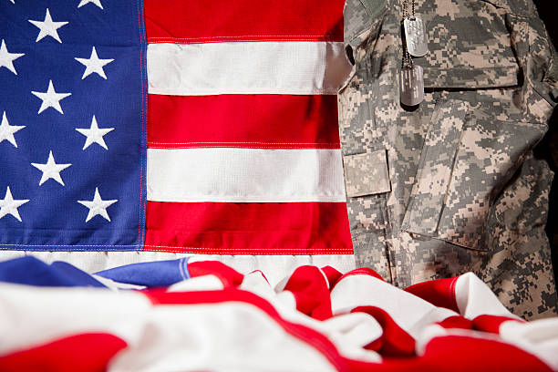 istock U.S.A. military uniform hangs beside American flags. Respect, patriotism. 470523710
