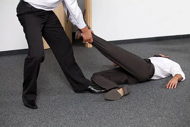 Photo of Businessmen pulling colleague's leg at office