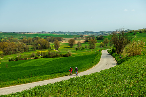 Monferrato Piedmont, Italy - April 11, 2015: Two cyclists are training for a race riding in the hills in a beautiful sunny day.
