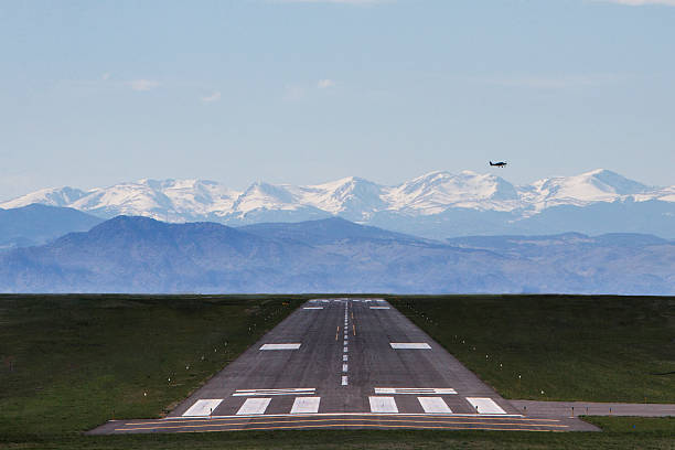 istock Airplane flying over runway with mountains in the background 470548578