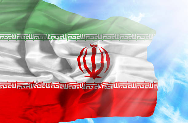 istock Iran waving flag against blue sky with sunrays 470549417