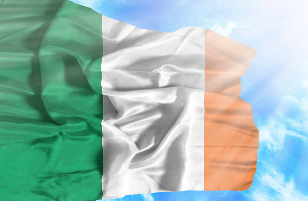 istock Ireland waving flag against blue sky with sunrays 470549455