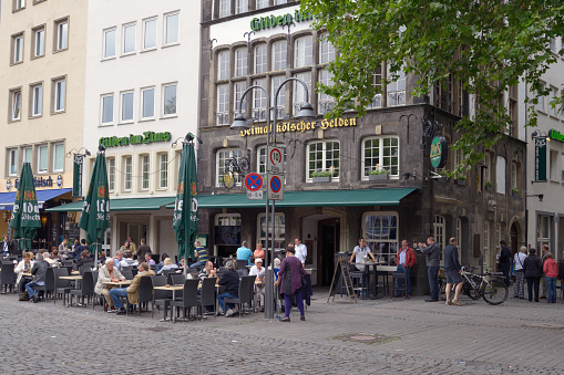 Cologne, Germany - June 30, 2013: People resting in the street terrace of the restaurant Gilden in Zims. Founded in 1920, the restaurant was fully renovated in 2006-2009