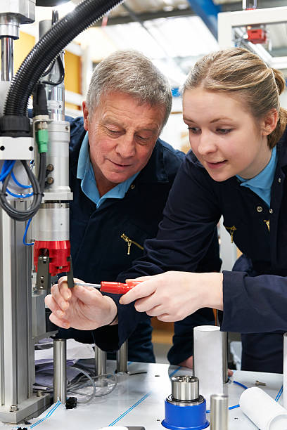 istock Engineer And Female Apprentice Working On Machinery In Factory 470556165