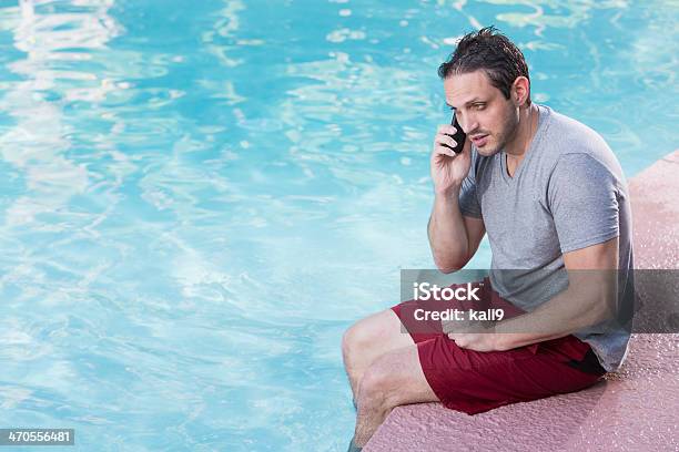 Photo libre de droit de Un Homme Parle Au Téléphone Au Bord De La Piscine banque d'images et plus d'images libres de droit de 35-39 ans - 35-39 ans, Adulte, Adulte d'âge moyen