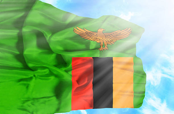 istock Zambia waving flag against blue sky with sunrays 470556869