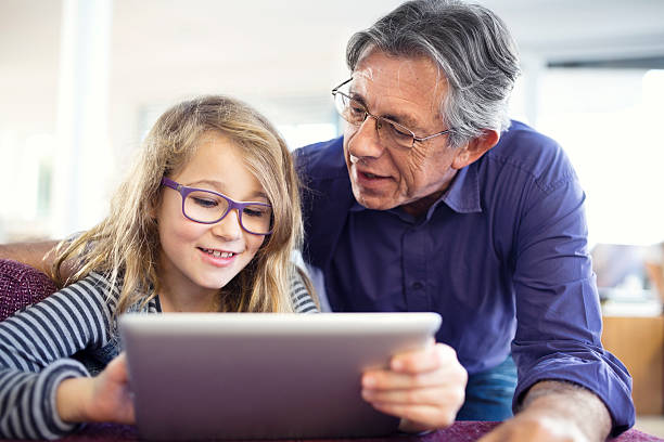 istock grandfather and granddaughter using a digital tablet 470557199
