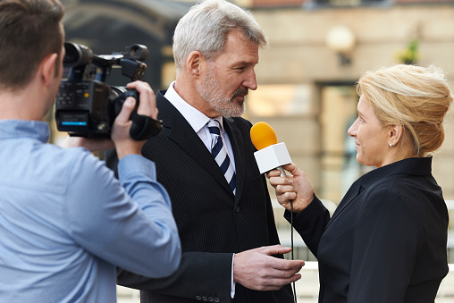 Periodista mujer con micrófono entrevistas ejecutivo photo