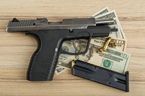 istock gun with bullet on US dollar banknotes 470568410