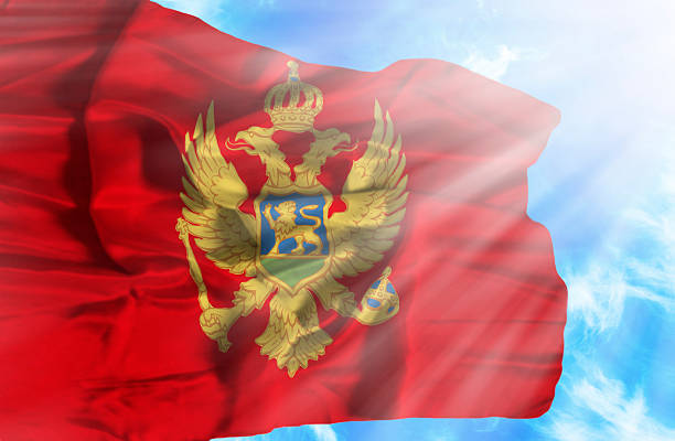 istock Montenegro waving flag against blue sky with sunrays 470569147