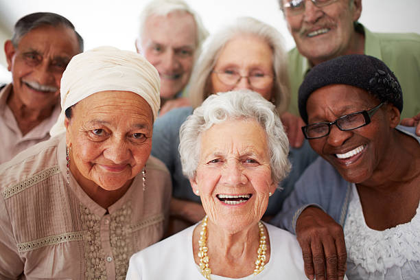 Enjoying life to the fullest everyday A group of seniors smiling together while in a retirement home adult age stock pictures, royalty-free photos & images