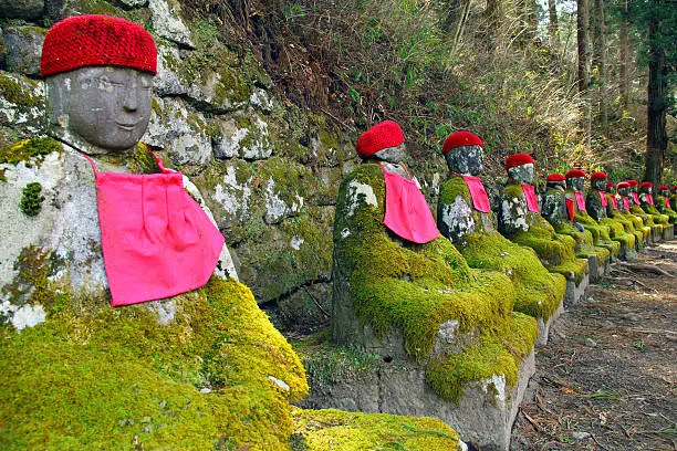 Old mossy stone statues of Jizo in Nikko, Japan
