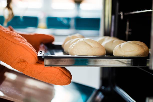 baker mãos com potholder ao lado de folha de metal cookie - whole cake fotos - fotografias e filmes do acervo