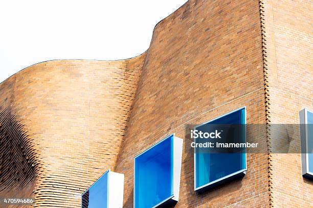 Top Part Abstract Curve Brick Building With Squre Blue Windows Stock Photo - Download Image Now