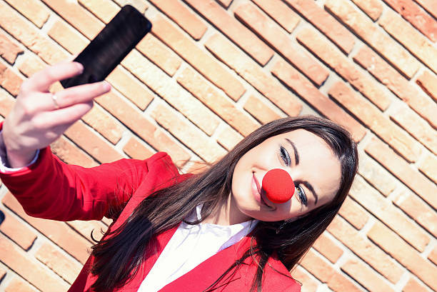 donna d'affari prendendo selfie - curtain red color image clown foto e immagini stock