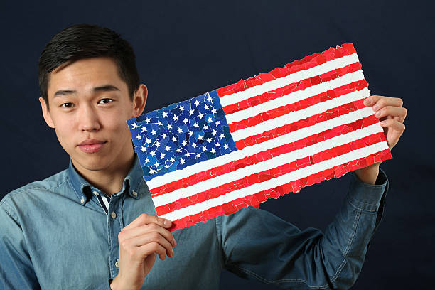 istock Young Asian student showing US national flag 470598320