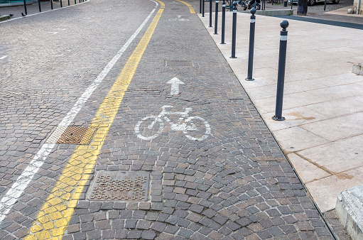 One-way bicycle lane on a cobbled street with signs painted on the cobblestones.